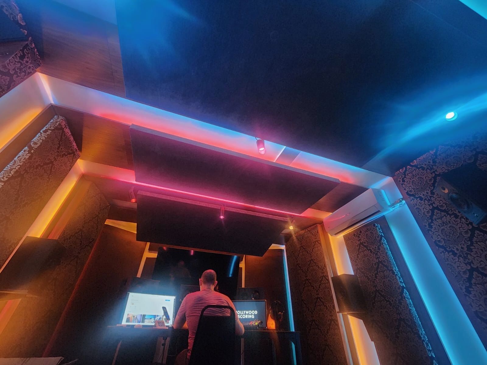 SonikBox mobile studio control room, neon-lit, with an engineer at the desk.
